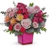 Pink and peach flower arrangement in a bright pink vase