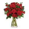 Red roses and carnations in a clear glass vase