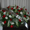 Large red and white rose funeral spray with a memorial ribbon