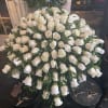 Large arrangement of white roses in a black container