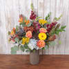 Mixed bouquet of orange and yellow flowers in a ribbed vase