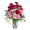 Bouquet of red roses and pink lilies in a clear glass vase