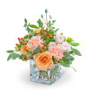 Peach and blush roses with carnations in a clear square vase