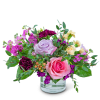 Pink and lavender roses in a clear glass vase