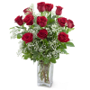 Red roses arranged in a clear glass vase with white filler flowers