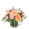 Peach and pink roses with carnations in a glass vase