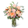 Peach and pink roses in a clear glass vase