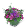 Pink and purple floral arrangement in a clear square vase