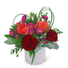 Red and orange roses with purple daisies in a white vase