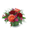 Arrangement of red and peach roses with purple daisies in a vase