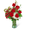 Bouquet of red roses and white flowers in a clear glass vase