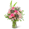 Pink roses and carnations in a clear glass vase with white snapdragons
