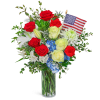Bouquet of red, white, and blue flowers in a glass vase with a small American flag