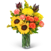 Bouquet of sunflowers, orange roses, and pink carnations in a glass vase