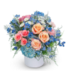 Bouquet of peach and pink roses with blue flowers in a white vase
