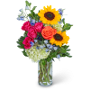 Bouquet of sunflowers, roses, and blue flowers in a glass vase