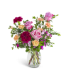 Mixed bouquet of pink roses, red and peach carnations in a clear glass vase.