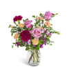 Mixed bouquet of pink roses and red and peach carnations in a clear glass vase