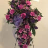 Purple and pink standing floral spray on an easel with a ribbon bow