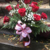 Bouquet of red roses with baby's breath in a vase and ribbon