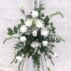 White floral standing spray on a black easel