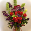 Bouquet of red roses and purple flowers in a glass vase