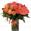 Bouquet of orange and coral roses in a glass pitcher vase