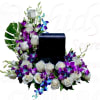 White roses and purple orchids arranged around a black rectangular vase