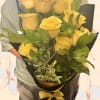 Bouquet of yellow roses wrapped in black paper with a yellow ribbon