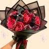 Bouquet of glittery red roses wrapped in black paper with a ribbon