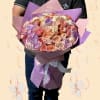 Large bouquet of pastel roses wrapped in purple and pink paper