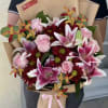 Bouquet of pink roses and lilies wrapped in brown paper