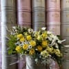 Yellow roses and white daisies arranged in a round hat box