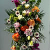 Standing Spray for a funeral service is vibrant tones made with spring