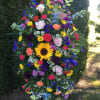 Large standing spray with multicolored flowers on a black easel