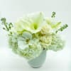 White floral arrangement in a white vase with large blooms