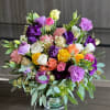 Mixed bouquet of roses and lisianthus in a glass vase