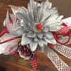 Silver artificial flower corsage with red ribbon accents