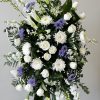 White and purple funeral spray with roses, lilies, and chrysanthemums