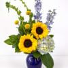 Sunny bouquet with sunflowers, blue hydrangea, delphinium and Bells of Ireland in a cobalt glass vase