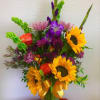Vase arrangement containing sunflowers, glads, roses, etc.. 