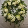 White rose and hydrangea wreath on a black stand