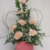 Peach carnations in a pink box with white filler flowers