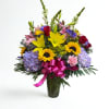 Mixed bouquet of lilies, roses, sunflowers, and hydrangeas in a glass vase