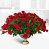 Large arrangement of red roses in a gold pedestal vase