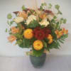 Mixed bouquet in a green vase with yellow, white, and red flowers