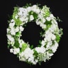 White floral wreath with roses and orchids on a black background