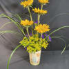 Yellow sunflowers in a decorated ceramic vase with purple filler flowers