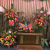 Tropical flowers arranged in a wreath around the urn, a standing spray