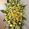 Large yellow floral standing spray with roses and lilies
